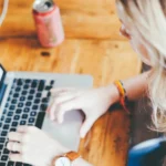 Kobieta pracuje przy laptopie w domu, wybiera kursy językowe online dla dorosłych